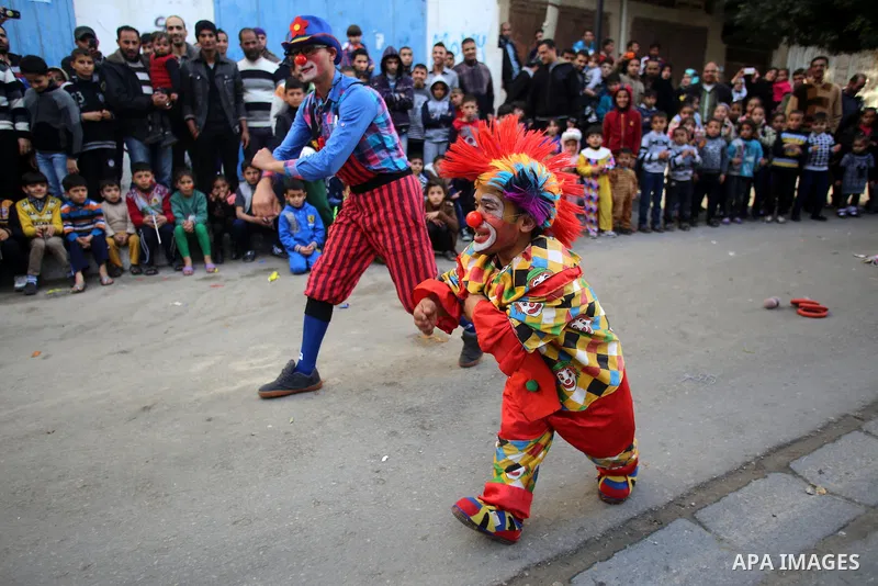 Clowns perform in front of Palestinian children during a street game organised by volunteers of the Friday of Joy Initiative, in al-Shati refugee camp, in Gaza city, February 6, 2015. Ten Palestinian volunteers organise...