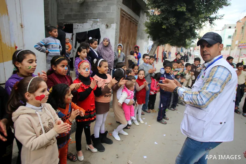 A volunteer of the Friday of Joy Initiative, plays with children in the street in al-Shati refugee camp, in Gaza city, February 6, 2015. Ten Palestinian volunteers organise street games, painting and drama, every Friday...