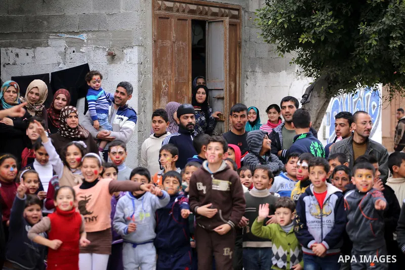 Palestinian children attend a street game organised by volunteers of the Friday of Joy Initiative, in al-Shati refugee camp, in Gaza city, February 6, 2015. Ten Palestinian volunteers organise street games, painting and...