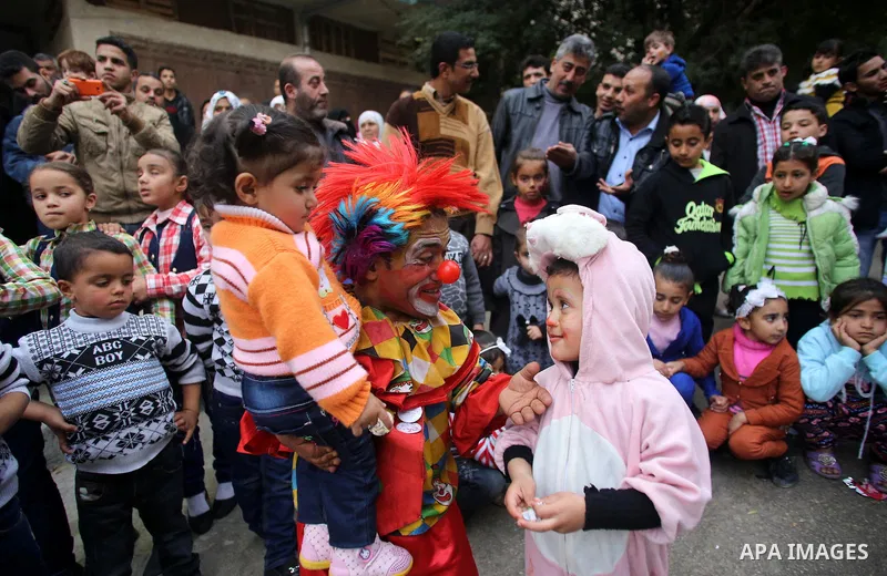A clown plays with Palestinian children during a street game organised by volunteers of the Friday of Joy Initiative, in al-Shati refugee camp, in Gaza city, February 6, 2015. Ten Palestinian volunteers organise street g...
