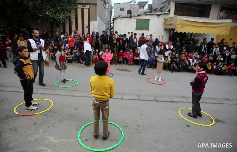 Volunteers of the Friday of Joy Initiative, play with Palestinian children in the street in al-Shati refugee camp, in Gaza city, February 6, 2015. Ten Palestinian volunteers organise street games, painting and drama, eve...