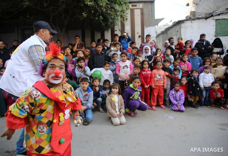 A clown performs in front of Palestinian children during a street game organised by volunteers of the Friday of Joy Initiative, in al-Shati refugee camp, in Gaza city, February 6, 2015. Ten Palestinian volunteers organis...