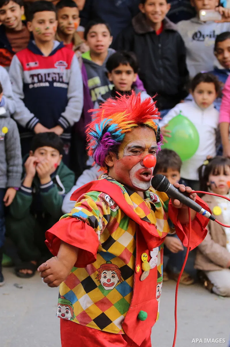 A clown performs in front of Palestinian children during a street game organised by volunteers of the Friday of Joy Initiative, in al-Shati refugee camp, in Gaza city, February 6, 2015. Ten Palestinian volunteers organis...