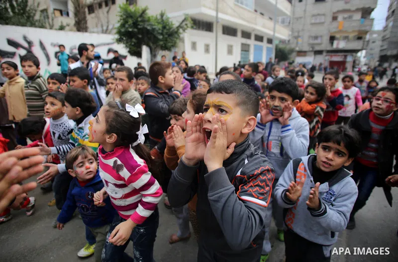Palestinian children attend a street game organised by volunteers of the Friday of Joy Initiative, in al-Shati refugee camp, in Gaza city, February 6, 2015. Ten Palestinian volunteers organise street games, painting and...