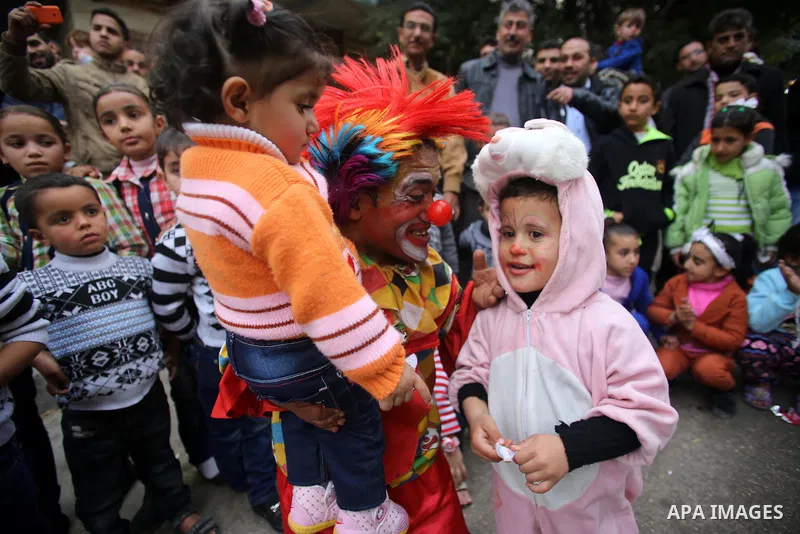 A clown plays with Palestinian children during a street game organised by volunteers of the Friday of Joy Initiative, in al-Shati refugee camp, in Gaza city, February 6, 2015. Ten Palestinian volunteers organise street g...