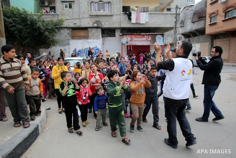 A volunteer of the Friday of Joy Initiative, plays with children in the street in al-Shati refugee camp, in Gaza city, February 6, 2015. Ten Palestinian volunteers organise street games, painting and drama, every Friday...