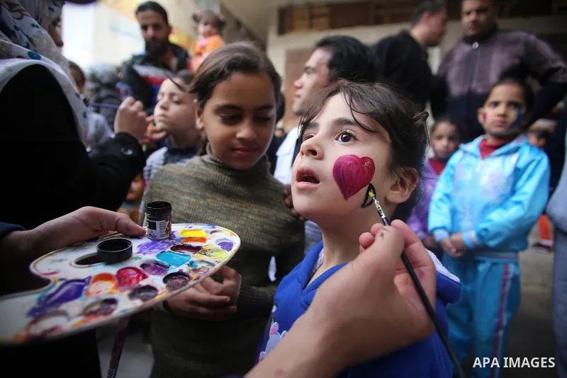 A Palestinian girl get her face painted during a street game organised by volunteers of the Friday of Joy Initiative, in al-Shati refugee camp, in Gaza city, February 6, 2015. Ten Palestinian volunteers organise street g...