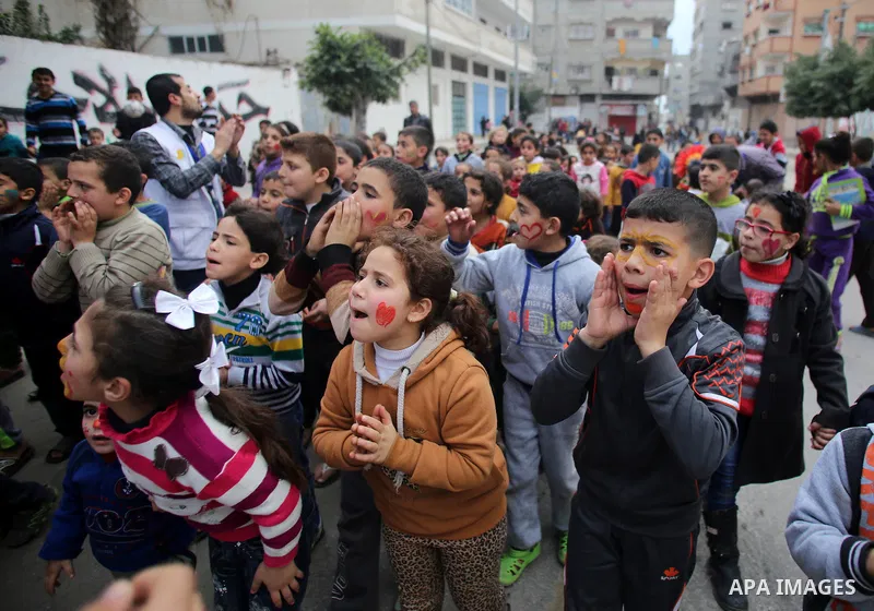Palestinian children attend a street game organised by volunteers of the Friday of Joy Initiative, in al-Shati refugee camp, in Gaza city, February 6, 2015. Ten Palestinian volunteers organise street games, painting and...
