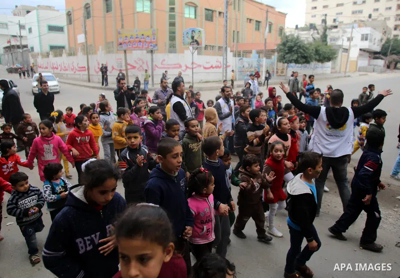 Palestinian children attend a street game organised by volunteers of the Friday of Joy Initiative, in al-Shati refugee camp, in Gaza city, February 6, 2015. Ten Palestinian volunteers organise street games, painting and...