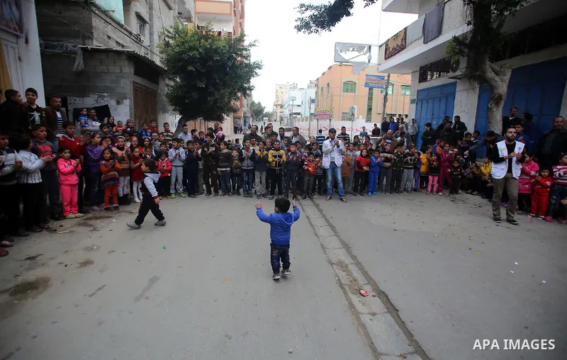 Volunteers of the Friday of Joy Initiative, play with Palestinian children in the street in al-Shati refugee camp, in Gaza city, February 6, 2015. Ten Palestinian volunteers organise street games, painting and drama, eve...