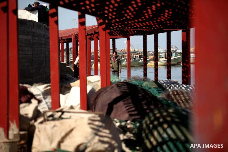 Palestinian fishermen work on their boat at the Gaza seaport, on February 7, 2015. The Israeli military boats on Friday morning opened fire on the Palestinian fishermen's boats near Al-Sudaneyya shore northwest of Gaza S...