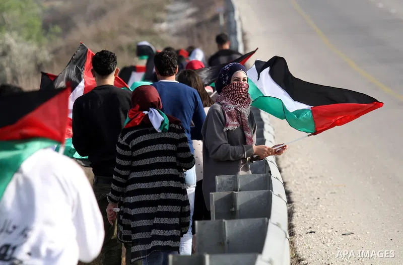 Palestinian protesters hold their national flags during a protest at the scene where Ahmed al-Najjar by Israeli soldiers on January 30, 2015, in the West Bank village of Burin, near Nablus on February 7, 2015. Local sour...