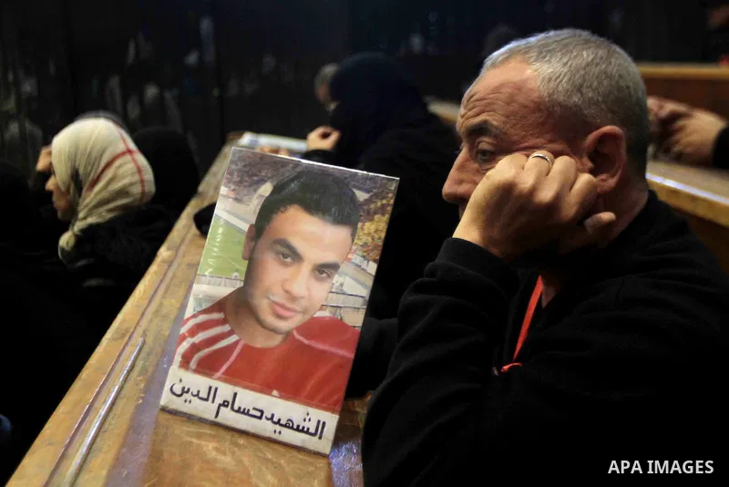 A relative of a killed man in the 'Port Said Massacre' holds his picture during the trial of suspects in Cairo on February 7, 2015. The defendants were originally given sentences ranging from 15 years to life in prison....