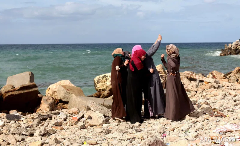 Palestinian girls stand in front of the beach at the Gaza seaport, on February 8, 2015. The governmental Committee to Break the Siege on Gaza declared last month the beginning of the rehabilitation of a waterway that wou...