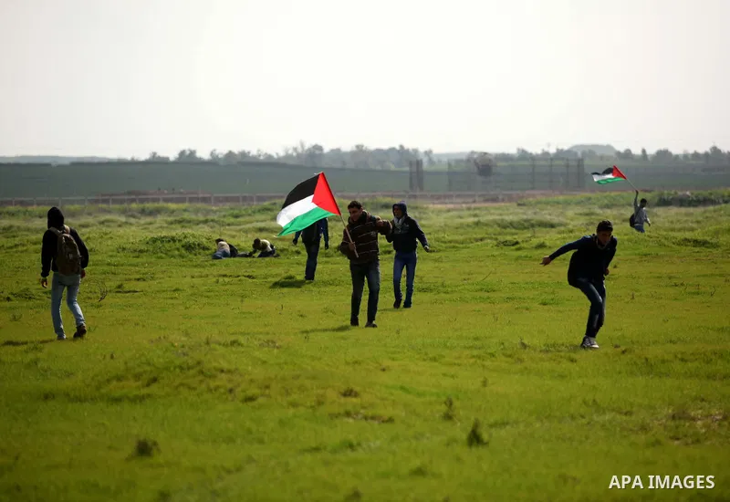 Palestinian protesters run for cover during a protest against the Israeli siege on Gaza strip near the Nahal Oz crossing east of Gaza City on February 09, 2015. Photo by Ashraf Amra