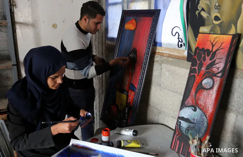 Palestinians paint pictures at an atelier in Rafah in the southern Gaza Strip, February 9, 2015. Three Palestinian artists use the remains of houses which were destroyed during the 51 day Israeli recent war on Gaza Strip...
