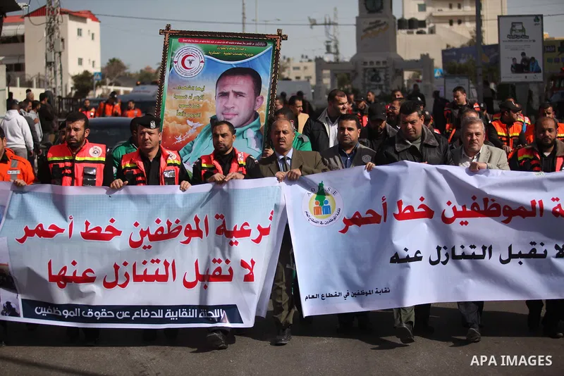 Palestinian employees of Civil defense march on a streets during a protest to demanding their salaries, in Gaza city, on February 10, 2015. Photo by Ashraf Amra