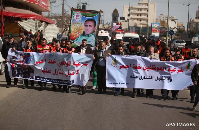 Palestinian employees of Civil defense march on a streets during a protest to demanding their salaries, in Gaza city, on February 10, 2015. Photo by Ashraf Amra