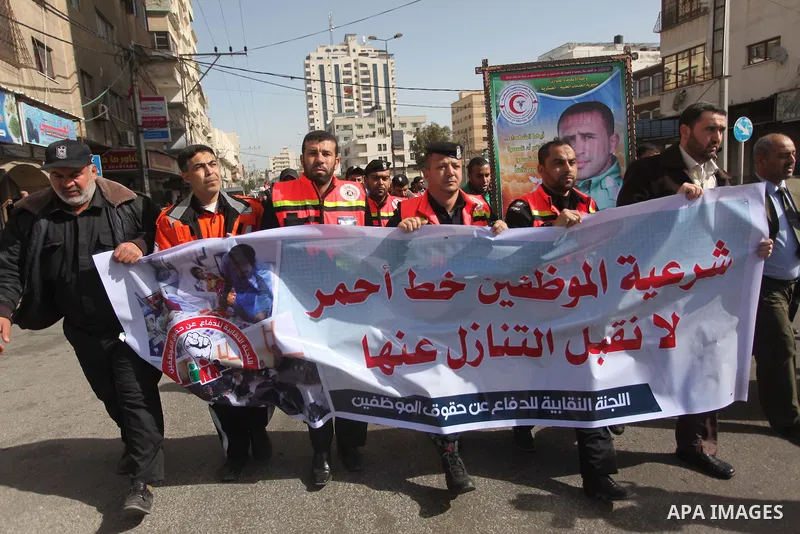 Palestinian employees of Civil defense march on a streets during a protest to demanding their salaries, in Gaza city, on February 10, 2015. Photo by Ashraf Amra