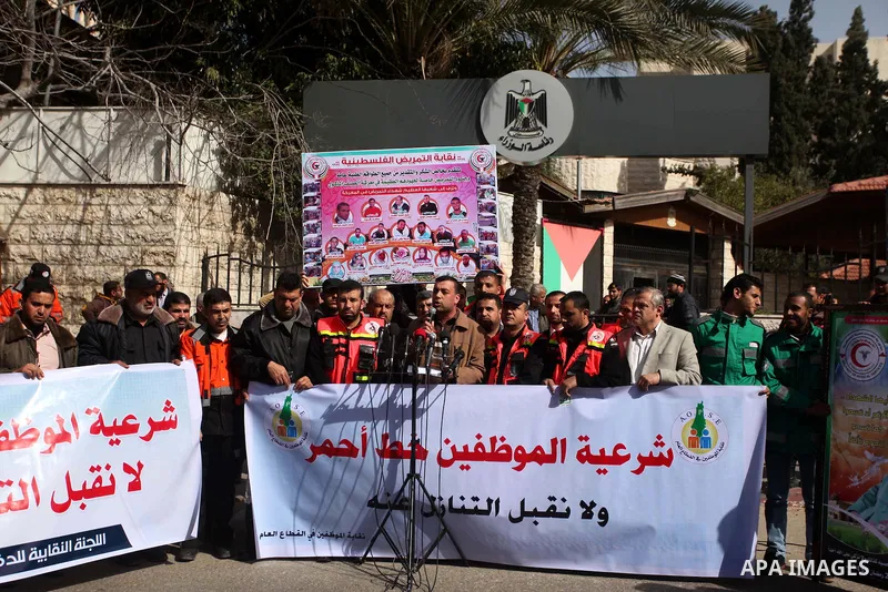 Palestinian employees of Civil defense march on a streets during a protest to demanding their salaries, in Gaza city, on February 10, 2015. Photo by Ashraf Amra