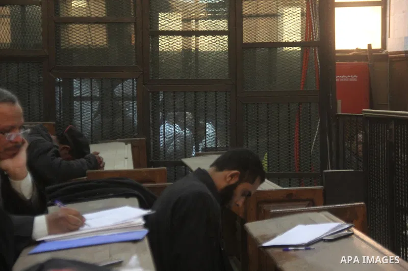 Egyptian defendants are seen behind bars during their trial, in a case known in media as "Rabaa Operation Room", in Cairo on February 11, 2015. The prosecution accused the defendants of several charges relating to prepar...