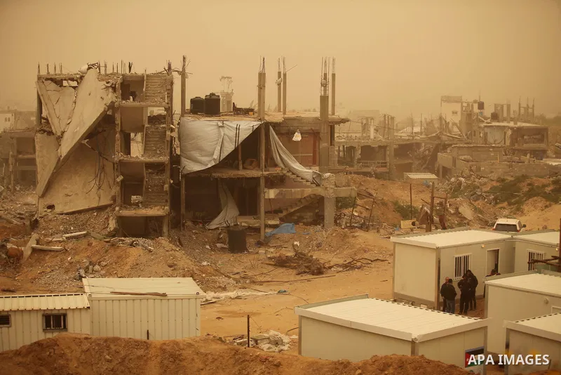 The remains of destroyed houses are seen during a sandstorm, in al-Shijaiyah destrict in Gaza city on February 11, 2015. Photo by Ashraf Amra