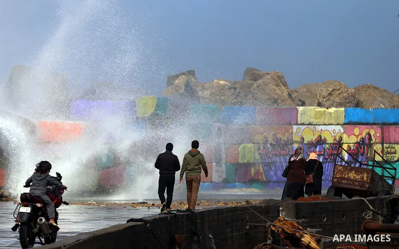 Palestinians walk at the Gaza seaport as a huge wave crash over a sea wall during a stormy day, east Gaza city on February 12, 2015. Photo by Yasser Qudih