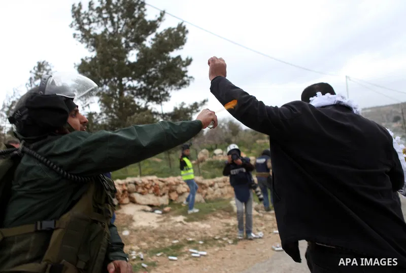 An Israeli border policeman sprays pepper spray at a Palestinian protester during clashes following a demonstration against Jewish settlements in the West Bank village of Bilin, near Ramallah February 13, 2015. Photo by...