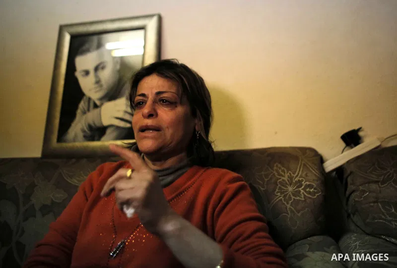 The mother of Arab-Israeli Muhammad Said Ismail Musallam gestures as she sits next to a framed portrait of their son, who is captured by the Islamic State (IS) group allegedly for spying for Israel's Mossad foreign intel...