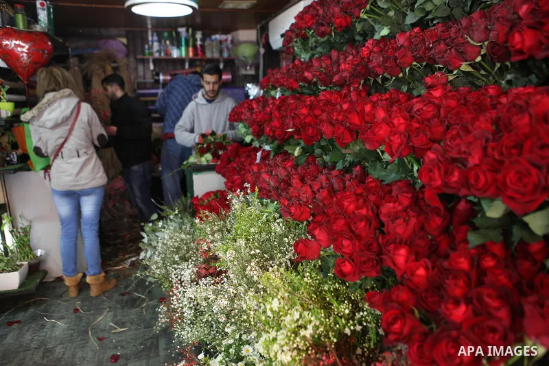 A Palestinian vendor sells a flowers on Valentine's day at his shop in the West Bank city of Ramallah, on Feb. 14, 2015. Valentine's Day is increasingly popular among younger Palestinians, many of whom have taken up the...