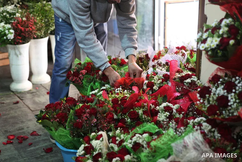 A Palestinian vendor sells a flowers on Valentine's day at his shop in the West Bank city of Ramallah, on Feb. 14, 2015. Valentine's Day is increasingly popular among younger Palestinians, many of whom have taken up the...