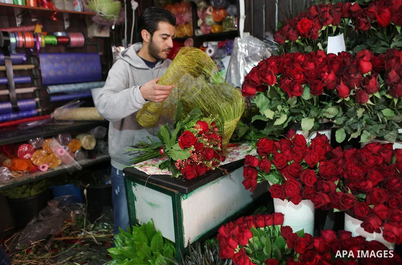 A Palestinian vendor sells a flowers on Valentine's day at his shop in the West Bank city of Ramallah, on Feb. 14, 2015. Valentine's Day is increasingly popular among younger Palestinians, many of whom have taken up the...