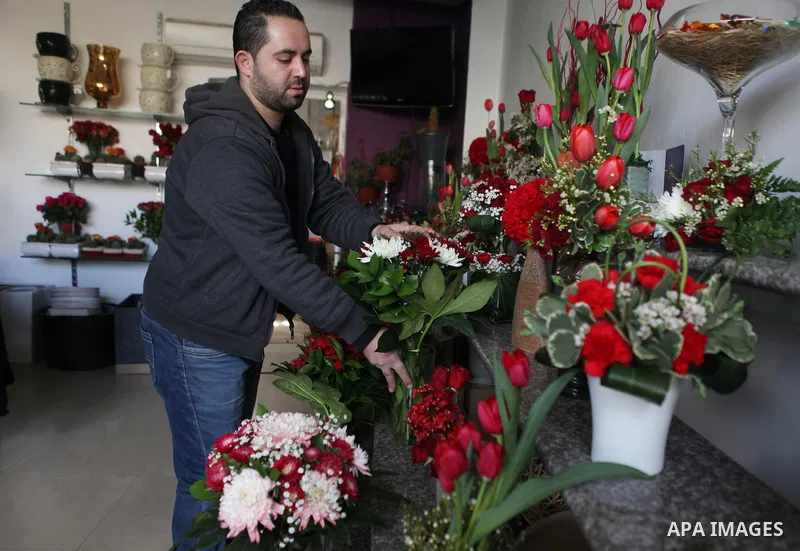 A Palestinian vendor sells a flowers on Valentine's day at his shop in the West Bank city of Ramallah, on Feb. 14, 2015. Valentine's Day is increasingly popular among younger Palestinians, many of whom have taken up the...