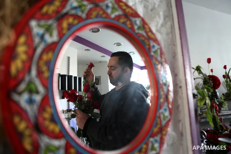 A Palestinian vendor sells a flowers on Valentine's day at his shop in the West Bank city of Ramallah, on Feb. 14, 2015. Valentine's Day is increasingly popular among younger Palestinians, many of whom have taken up the...