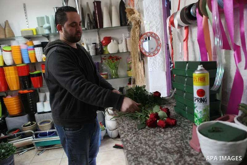 A Palestinian vendor sells a flowers on Valentine's day at his shop in the West Bank city of Ramallah, on Feb. 14, 2015. Valentine's Day is increasingly popular among younger Palestinians, many of whom have taken up the...