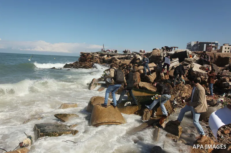 Palestinians throw flowers into the sea, in remembrance of the Chapel Hill shooting victims, in Gaza City, February 14, 2015. Three young Muslims were gunned down in Chapel Hill, North Carolina, this week. Newlywed Deah...