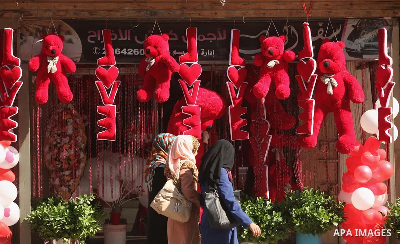 Palestinians walk past a shop displaying red teddy bears on Valentine's day in Gaza on February 14, 2015. Valentine's Day is increasingly popular in the region as people have taken up the custom of giving flowers, cards,...