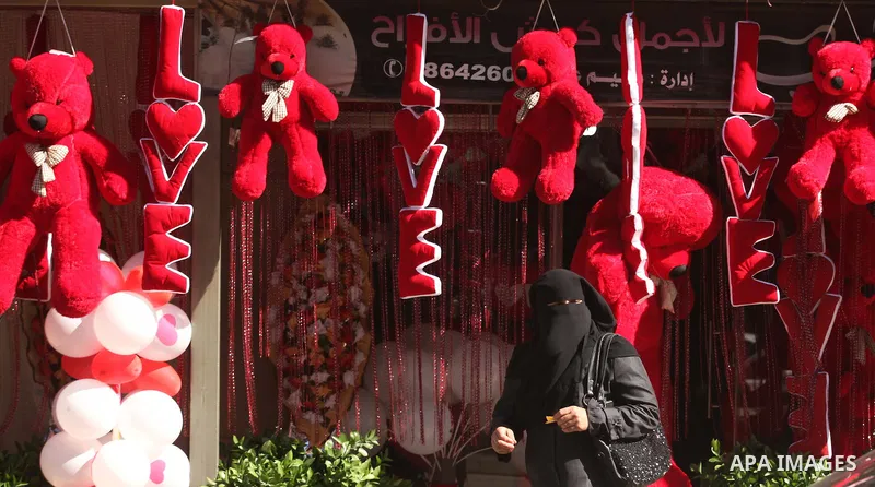 A Palestinian woman walks past a shop displaying red teddy bears on Valentine's day in Gaza on February 14, 2015. Valentine's Day is increasingly popular in the region as people have taken up the custom of giving flowers...