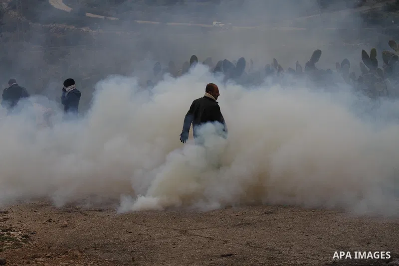 Palestinian Protesters run away from tear gas fired by Israeli border policemen during clashes following a protest against closure of the village road, in the West Bank village of Azzun near Qalqilya February 14, 2015. P...