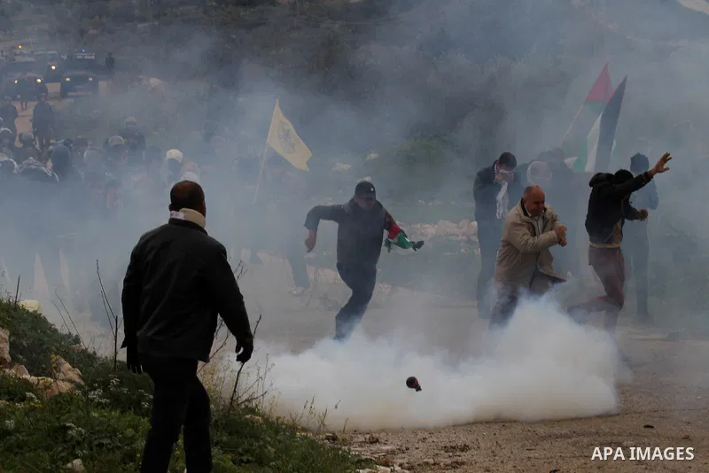 Palestinian Protesters run away from tear gas fired by Israeli border policemen during clashes following a protest against closure of the village road, in the West Bank village of Azzun near Qalqilya February 14, 2015. P...