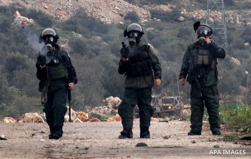 Israeli border policemen fire tear gas at Palestinian protesters during clashes following a protest against closure of the village road, in the West Bank village of Azzun near Qalqilya February 14, 2015. Photo by Nedal E...