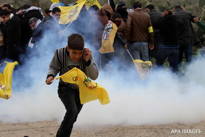 Palestinian Protesters run away from tear gas fired by Israeli border policemen during clashes following a protest against closure of the village road, in the West Bank village of Azzun near Qalqilya February 14, 2015. P...