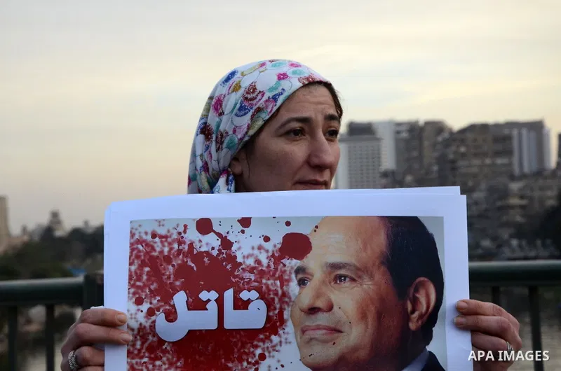Members of the April 6 movement hold placards during a demonstration of October bridge in Cairo, Egypt on February 14, 2015. Photo by Amr Sayed
