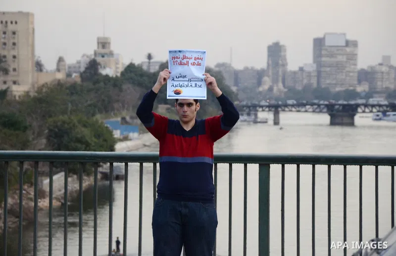 Members of the April 6 movement hold placards during a demonstration of October bridge in Cairo, Egypt on February 14, 2015. Photo by Amr Sayed