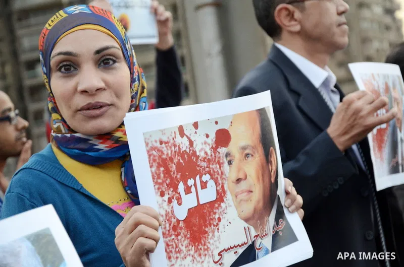 Members of the April 6 movement hold placards during a demonstration of October bridge in Cairo, Egypt on February 14, 2015. Photo by Amr Sayed