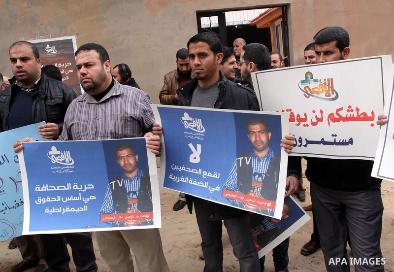 Palestinian journalists hold placards during a protest demanding release of their colleague Alaa al-Titi in Israeli jails, in Gaza city on February 15, 2015. Photo by Mohammed Asad