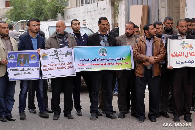 Palestinian journalists hold placards during a protest demanding release of their colleague Alaa al-Titi in Israeli jails, in Gaza city on February 15, 2015. Photo by Mohammed Asad