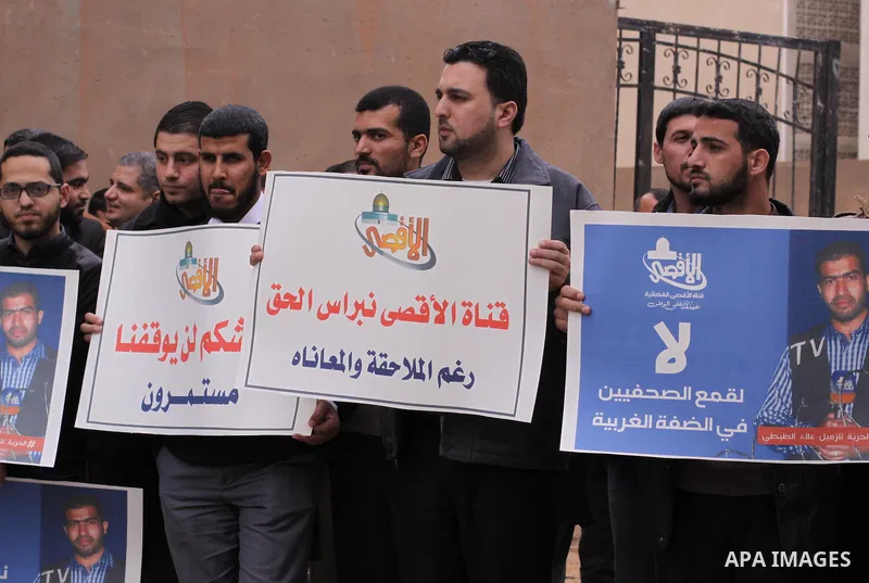 Palestinian journalists hold placards during a protest demanding release of their colleague Alaa al-Titi in Israeli jails, in Gaza city on February 15, 2015. Photo by Mohammed Asad