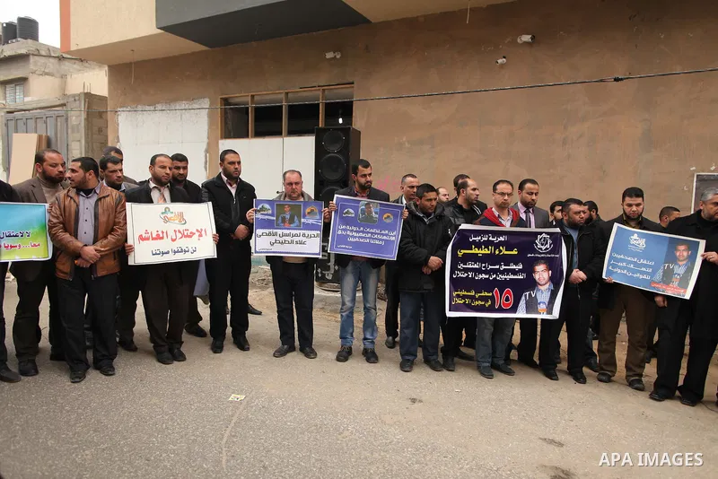 Palestinian journalists hold placards during a protest demanding release of their colleague Alaa al-Titi in Israeli jails, in Gaza city on February 15, 2015. Photo by Ashraf Amra