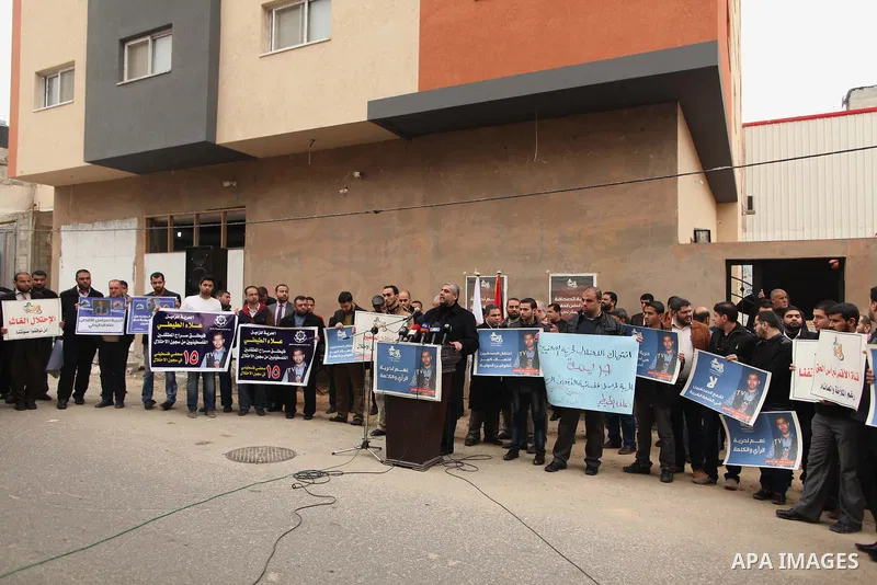 Palestinian journalists hold placards during a protest demanding release of their colleague Alaa al-Titi in Israeli jails, in Gaza city on February 15, 2015. Photo by Ashraf Amra